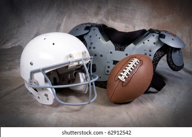 Football Helmet And Shoulder Pads On Tan Background