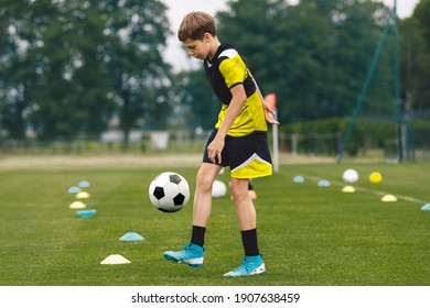 Football Juggling. Teenage Boy Juggling Soccer Ball On A Training Pitch. Happy Kid In Jersey Sportswear Practicing Soccer Skills
