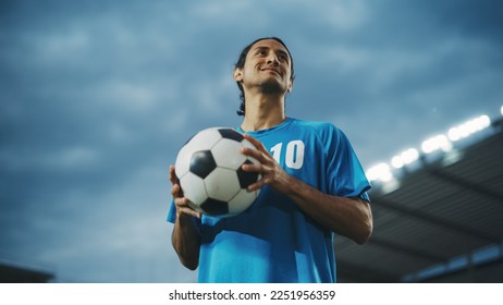 Football Match Championship, Portrait of Soccer Player Holding a Ball, Standing, Posing, Smiling. Professional Hispanic Footballer, Future Champion Ready to Win Cup, Tournament. Low Angle Shot - Powered by Shutterstock