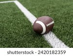 Football on hash marks of high school turf football field