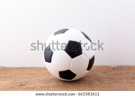 football on wooden with white cement background