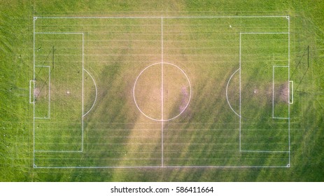 Football Pitch. Aerial Drone View Looking Down Vertically Onto An Empty Soccer Pitch With Shadows Cast By The Low Sun.