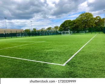 Football pitch and a cloudy sky. Green field. England.