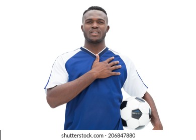 Football player in blue standing with the ball listening to anthem on white background - Powered by Shutterstock
