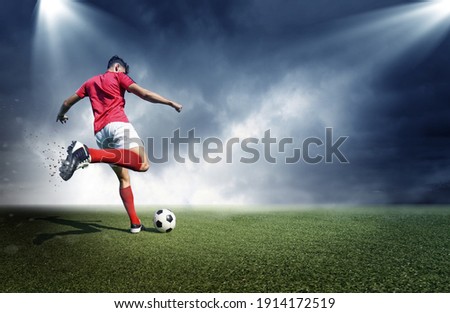 Football player, dark cloudy background. The imaginary stadium is modelled and rendered.	