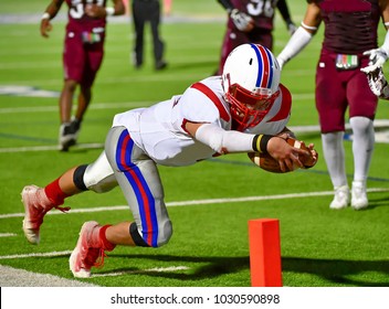 Football player diving forward for a touchdown during a game