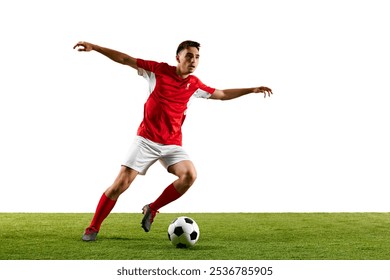 Football player dressed in red-white uniform, preparing for long-range pass, locked in action as he swings his leg mid-air during practice on green pitch. Concept of sport events, final game. Ad - Powered by Shutterstock