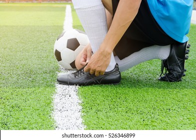 Football player getting ready for the game tying his shoes - Powered by Shutterstock