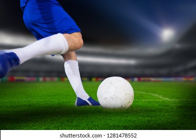 Football player kicking ball against soccer stadium  - Powered by Shutterstock