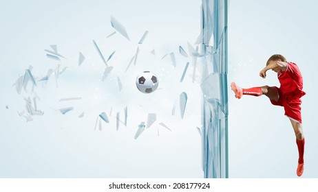 Football Player Kicking Ball In Jump And Breaking Glass