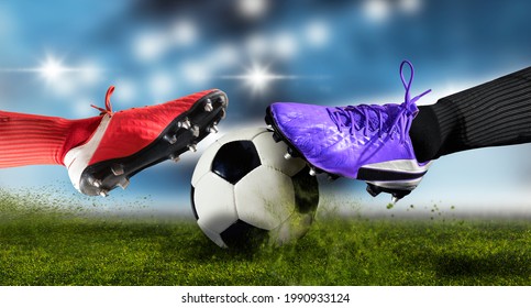 Football Player Man In Action On Dark Arena Background. Soccer Player Making Sliding Tackle