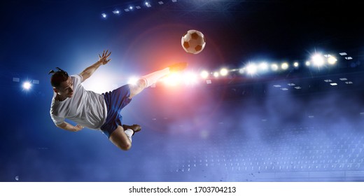 Football Player On Stadium Jumps To Kick A Ball