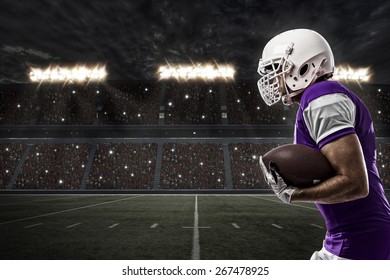 Football Player with a purple uniform running on a stadium. - Powered by Shutterstock