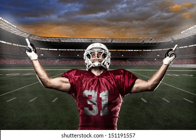Football Player with a Red uniform celebrating with the fans.