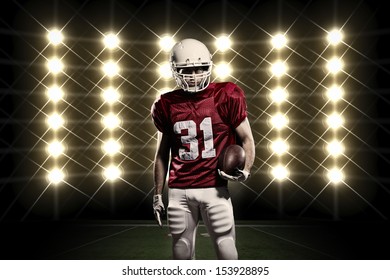 Football Player with a Red uniform in front of lights.