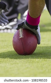 A Football Player Setting Up To Snap The Ball During A Game.