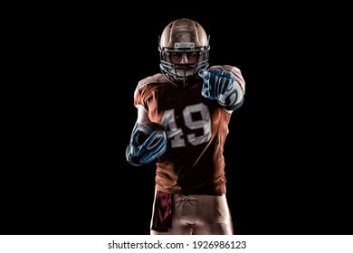 Football Player player with a superhero pose wearing a blue uniform on a black background with blue lights. - Powered by Shutterstock