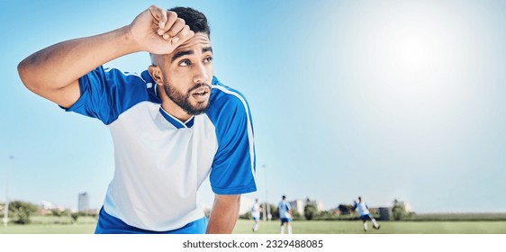 Football player, tired and man sweating outdoor on a field for sports and fitness competition. Male soccer or athlete person on a break while exhausted from training workout with mockup banner space - Powered by Shutterstock