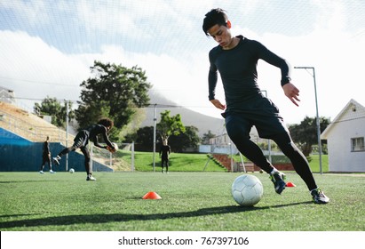 Football player training in soccer field. Young soccer player practicing ball control on training session. - Shutterstock ID 767397106