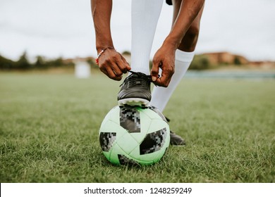 Football player tying her shoelaces - Powered by Shutterstock