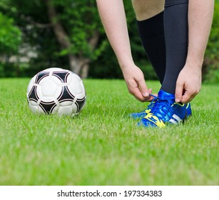 Football player tying his shoes on the field. - Powered by Shutterstock