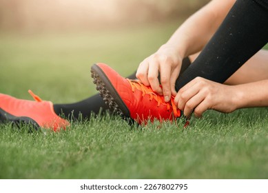 Football player tying shoelaces. The concept of preparation and safety of the game of football. Children's football club. Close-up of a football boot. - Powered by Shutterstock