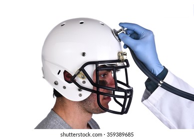 A Football Player Wearing A Helmet With Doctors Hand Holding A Stethoscope On The Crown Of The Helmet. Sports Concussion Concept, And Related Conditions, CTE, Alzheimer's, Parkinson's.