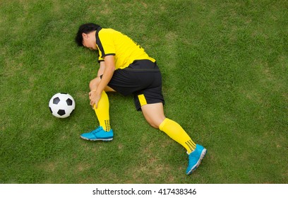 Football player in Yellow lying injured on the pitch. - Powered by Shutterstock