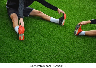 Football players doing stretching before match on green pitch - sport, active photo with space for your montage - Powered by Shutterstock