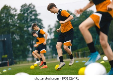 Football Players on Training. Teenage Boys Training With Small Balls. Soccer Summer Camp for Young Boys. Happy Football Players on Practice Session. Youth Team Kicking Balls on Turf Pitch - Powered by Shutterstock