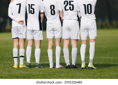 Football Players Standing In A Wall During Free Kick. Soccer Players In White Sports Jersey Shirts With Black Numbers On Back. Footballers In Turf Cleats. Soccer Teenage Boys In A Team