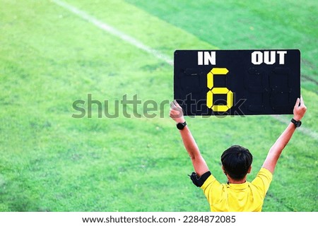 Football referee holds up sign indicating overtime Injury to a player during 6 minutes of extra time is the overtime charge of football stadiums in Thailand. used as an illustration