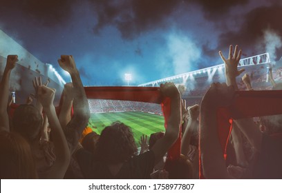 Football scene at night match with with cheering fans at the stadium - Shutterstock ID 1758977807
