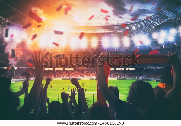 Football scene at night match with cheering fans\
at the stadium