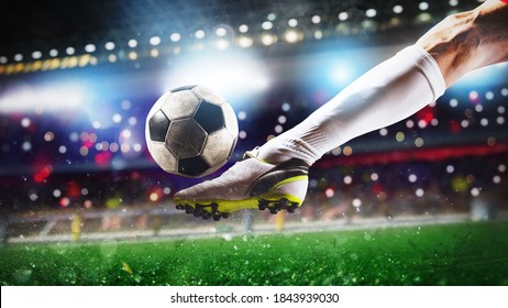 Escena de fútbol en partido de noche con el cierre de un zapato de fútbol golpeando la pelota con poder