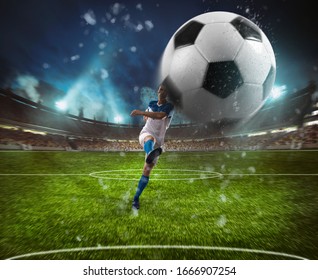 Football Scene At Night Match With Player In A White And Blue Uniform Kicking The Ball With Power