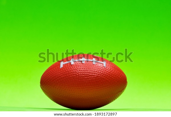 Football sitting at ground level isolated on\
green background with copy space\
above.