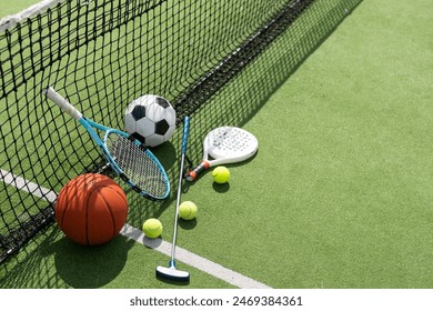 football soccer ball basketball tennis ball and racket laid on grass at sunset - Powered by Shutterstock