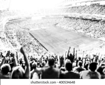 Football- Soccer Fans Cheer Their Team And Celebrate Goal In Full Stadium With Open Air  With Bright Lighting Beam     -blurred.