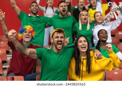 Football or soccer fans are cheering for their team at the stadium on the match.  - Powered by Shutterstock