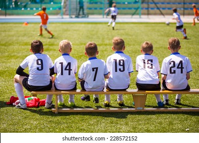 Football soccer match for children. Kids waiting on a bench. - Powered by Shutterstock