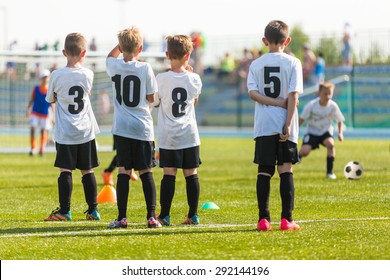 Football Soccer Match For Children. Kids Waiting On A Bench.