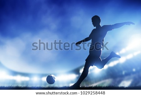Football, soccer match. A player shooting on goal. Lights on the stadium at night.