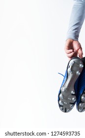 Football Soccer Player Holding Football Boots Cleats In Hand On White Background With Copy Space.