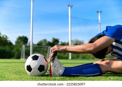 football soccer player stretching during warm up before kick ball in match league in stadium with healthy sport concept - Powered by Shutterstock