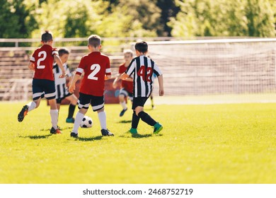 Football Soccer Players Running with Ball. Youth Soccer League For Kids. Boys Playing Football Game on School Pitch. Children in Sports Uniforms Compete in Football Soccer League - Powered by Shutterstock