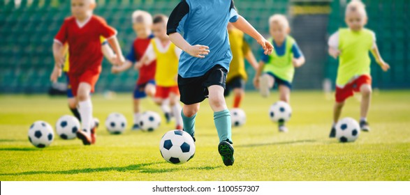 Football soccer training for kids. Children football training session. Kids running and kicking soccer balls. Young boys improving soccer skills