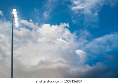 Football Stadium Lights With Cloudy Sky In The Background. Photo Of A High School Football Or Soccer Game On A Friday Night	