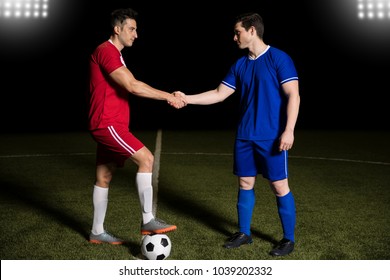 Football team captains standing at center line with ball and handshake before soccer match - Powered by Shutterstock