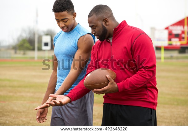 Football training day. American Football. 
Football coach training an athlete.

